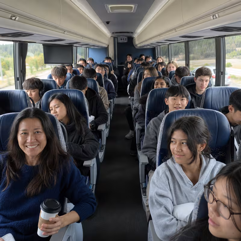 Group boarding a white charter bus for School Transportation transportation in Philadelphia